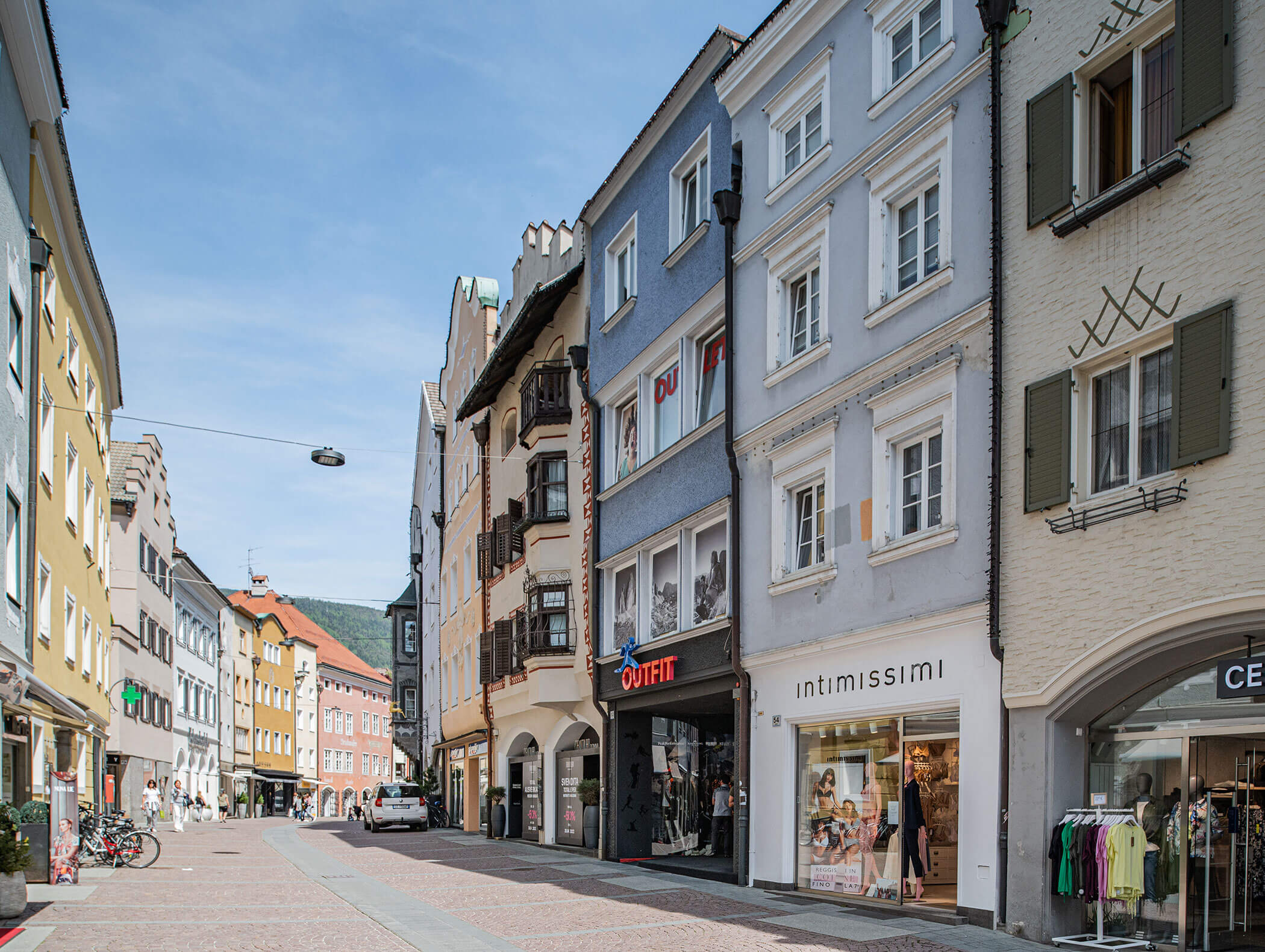 Strada pedonale fiancheggiata da negozi e appartamenti colorati in una giornata di sole in una città europea. - Hotel Moosmair