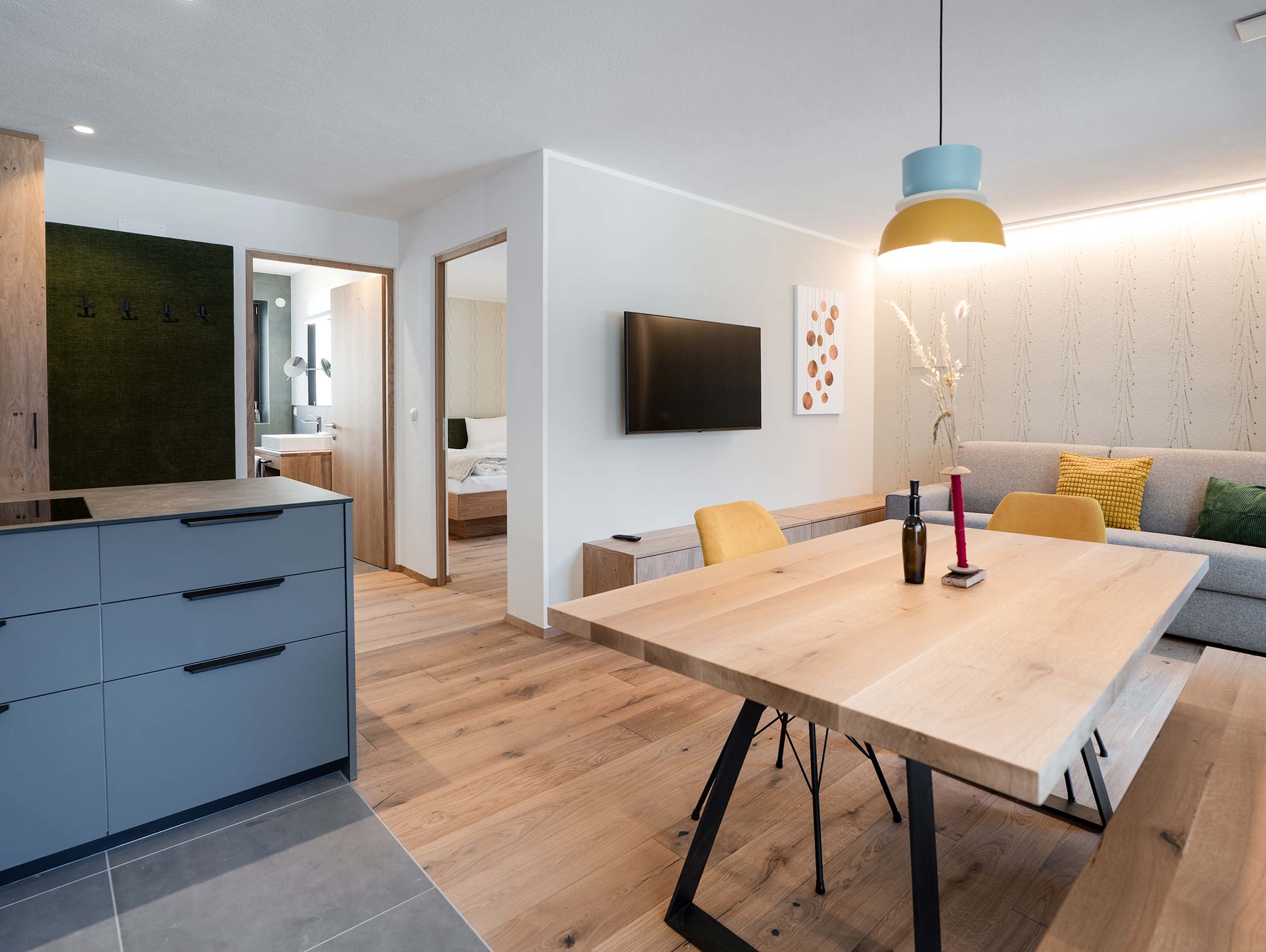 Moderna zona giorno e pranzo a pianta aperta con pavimenti in legno, mobili eleganti e luce naturale. - Hotel Moosmair
