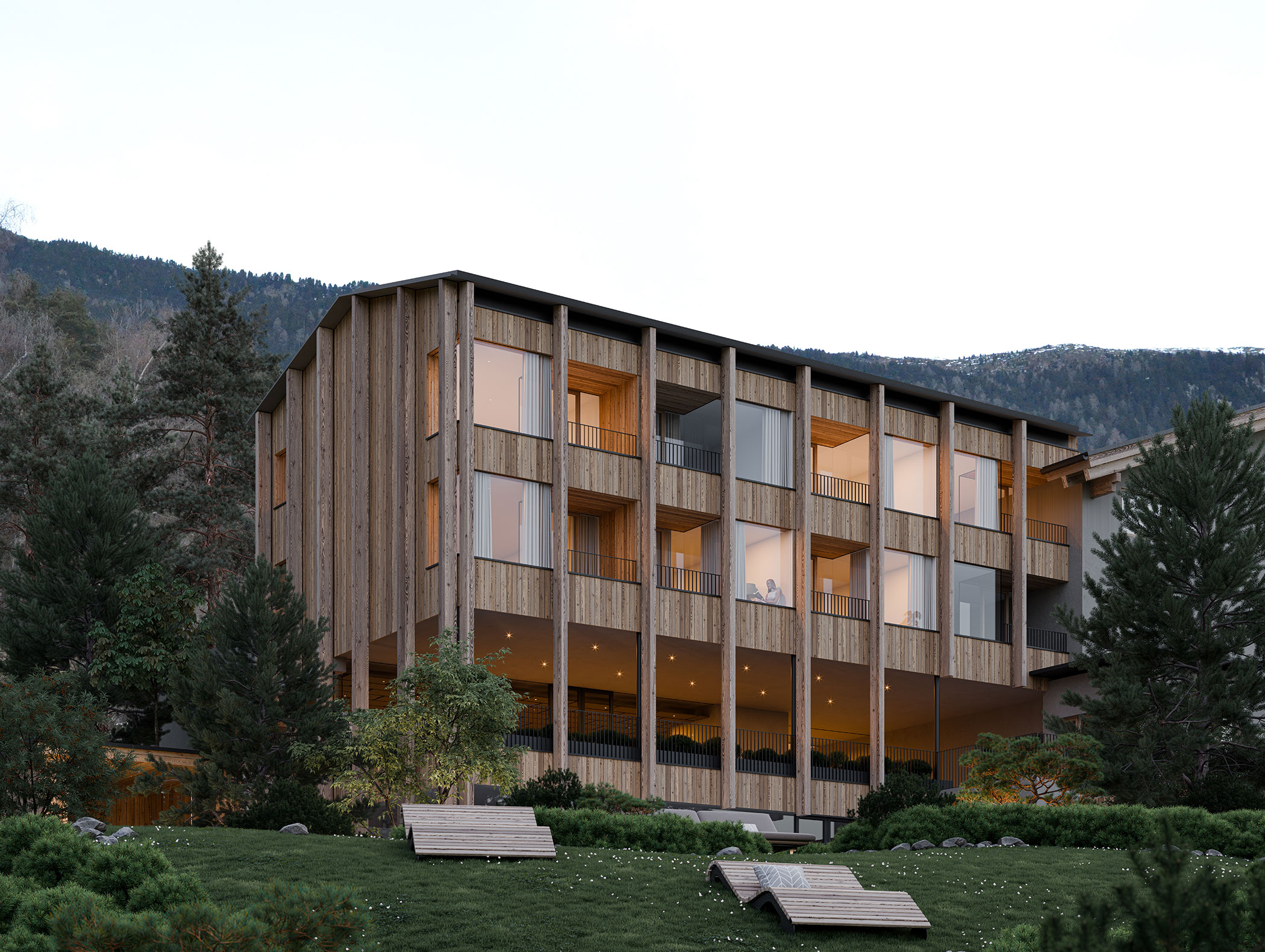 Modernes Holzgebäude mit großen Fenstern und Balkonen, umgeben von Bäumen und Bergen im Hintergrund. - Hotel Moosmair