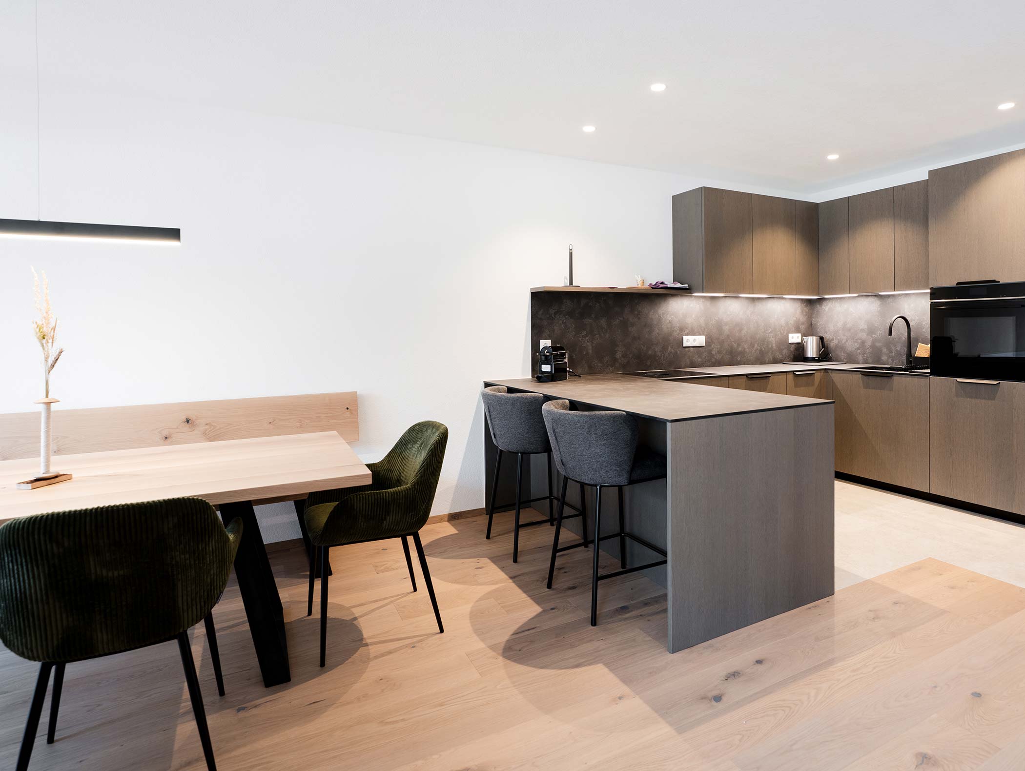 Cucina e zona pranzo moderne con pavimenti in legno, armadietti scuri e mobili contemporanei. - Hotel Moosmair